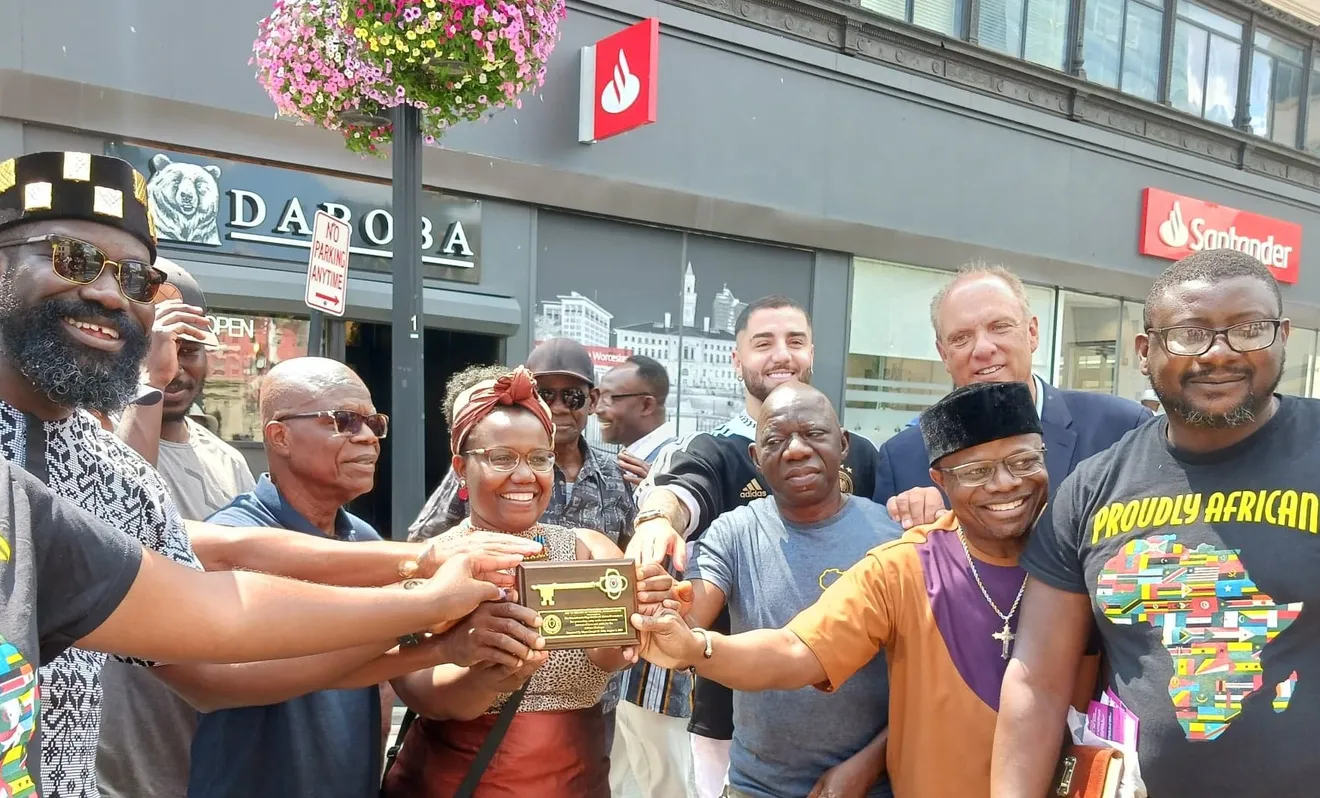 "📸 Capture the exhilarating moment as volunteers rally around Dr. THIDI TSHIGUVHO, beaming with pride, while she accepts the key to the city from Mayor Joe Pettty, representing the Massachusetts Organization of African Descendants, at the electrifying first African festival in Worcester on August 5. Photo credit: Worcester Telegram and Gazette."