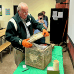 Jack Chiras, former history teacher, opens the time capsule during the ceremony